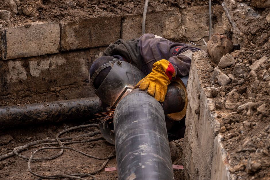 Close-up of a drainage pipe being repaired with relining equipment in a suburban garden